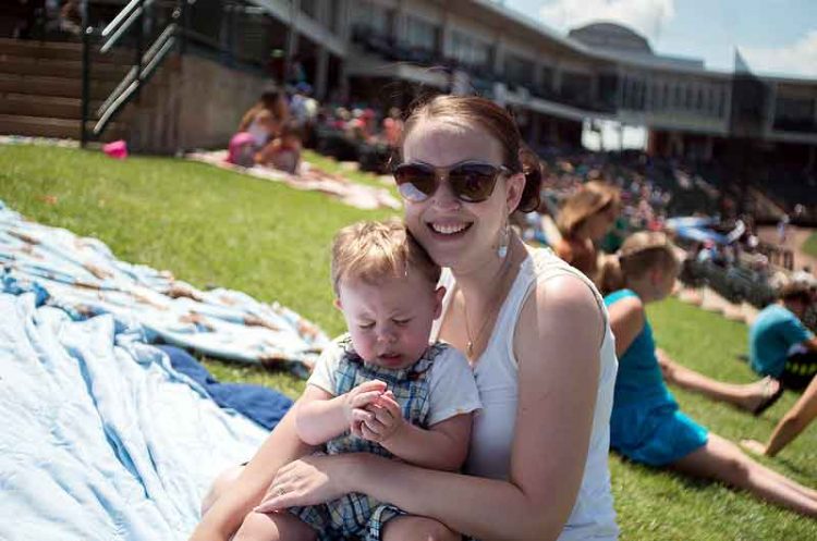 baseball mom holds child at baseball game my biggest fan