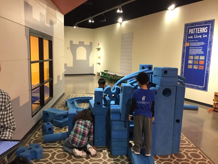 Young kids build a fort with giant foam blocks.
