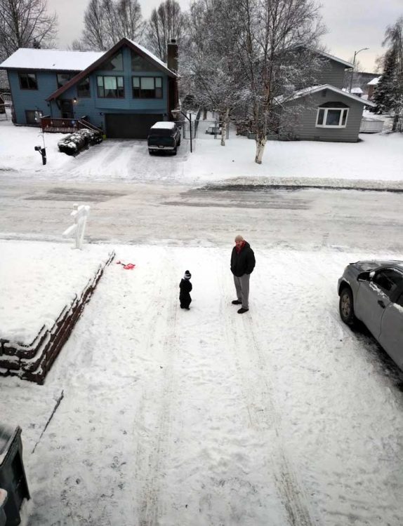 father son stand in driveway in snow after earthquake talk
